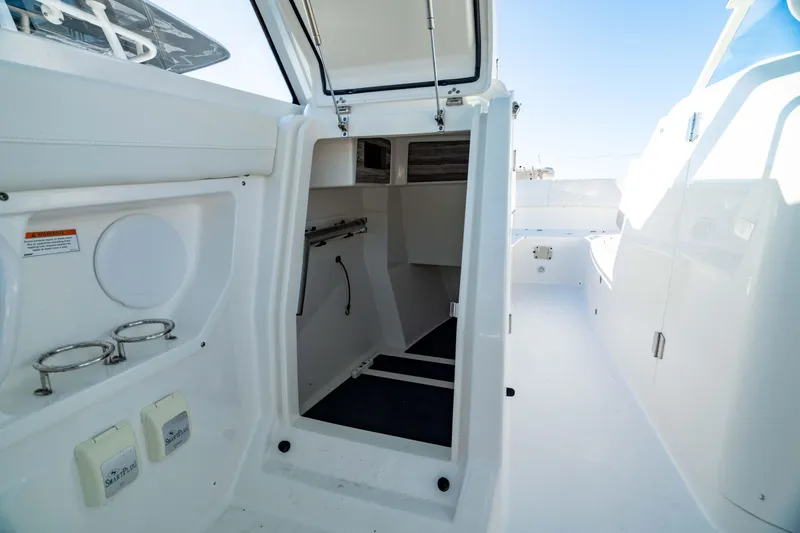 Slide: The Image of 2022 Edgewater 262 CX boat interior with open cabin door and storage compartments. - 25