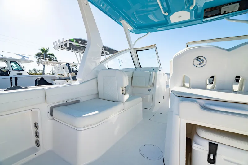 Slide: The Image of 2022 Edgewater 262 CX boat interior with white seating and blue canopy. - 27