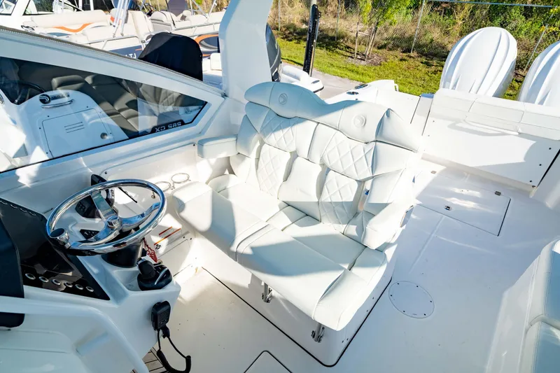Slide: The Image of 2022 Edgewater 262 CX boat interior with white seating and steering wheel. - 3
