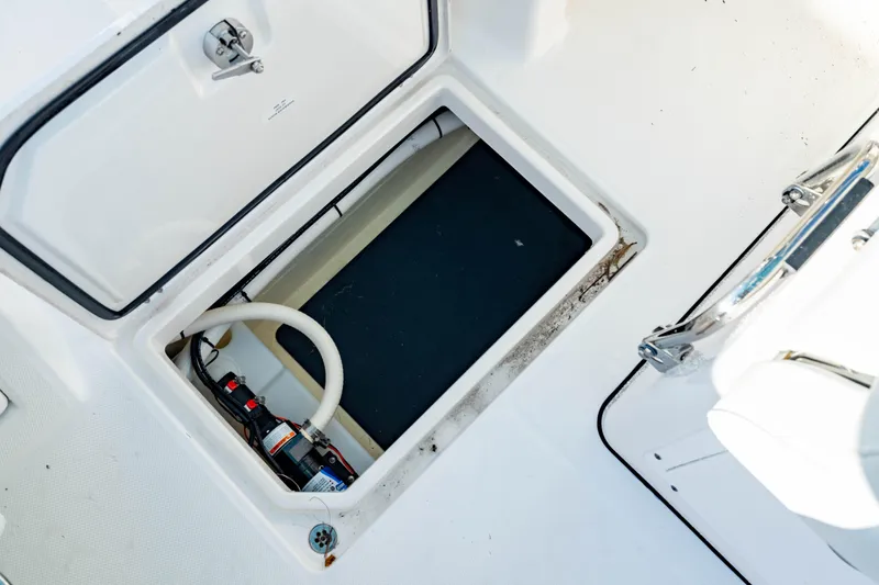 Slide: The Image of 2022 Edgewater 262 CX boat storage compartment with open hatch and visible equipment. - 32