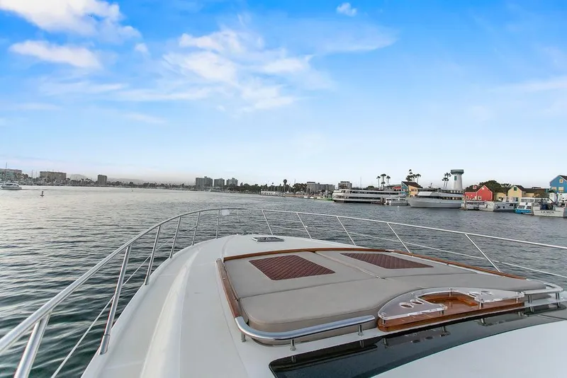 Slide: The Image of 2004 Riva 59 Mercurius yacht cruising in a scenic harbor under a clear blue sky. - 16