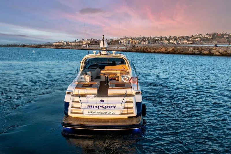 Slide: The Image of Riva 59 Mercurius yacht, 2004 model, cruising at sunset near coastal cityscape. - 3