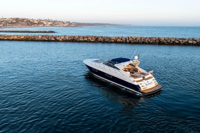 Slide: The Image of Luxury 2004 Riva 59 Mercurius yacht cruising in calm waters near rocky shoreline. - 31