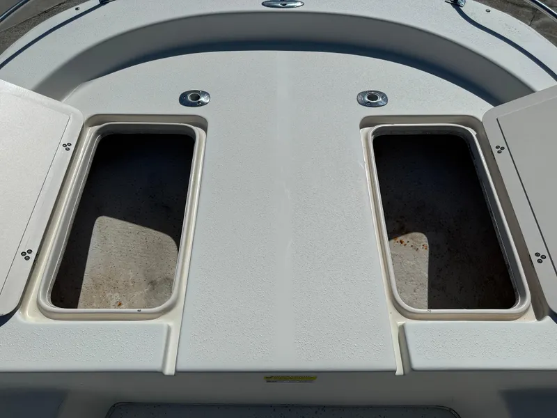 Slide: The Image of 2013 Carolina Skiff 218 DLV boat storage compartments open on deck. - 6