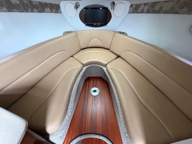 Slide: The Image of 2023 Crownline 264 CR cabin interior with beige seating and wood flooring. - 13