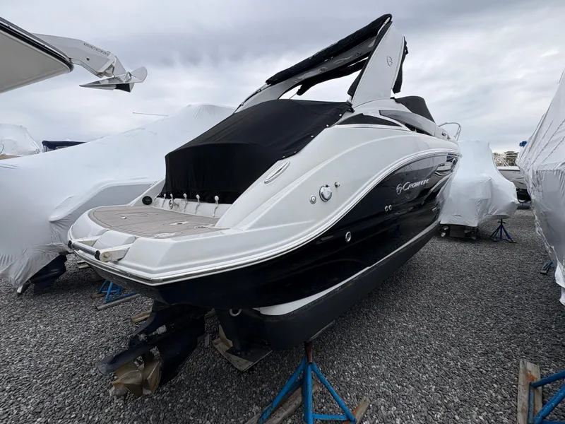 Slide: The Image of 2023 Crownline 264 CR boat on stands, covered, in a storage area. - 3