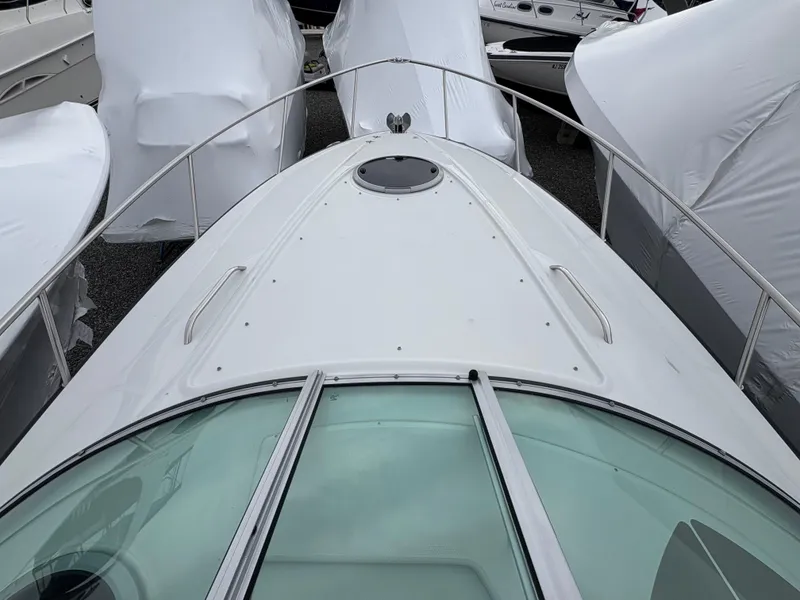 Slide: The Image of 2023 Crownline 264 CR boat, top view, docked among covered boats. - 5