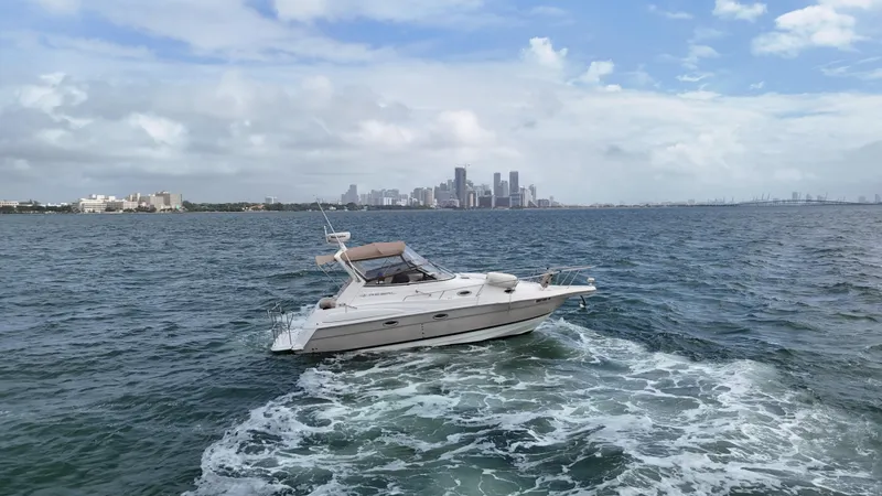 Slide: The Image of 2005 Regal Commodore 2860 boat cruising on ocean with city skyline in background. - 10