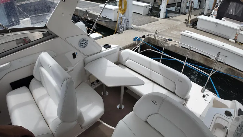 Slide: The Image of 2005 Regal Commodore 2860 boat interior with white seating and table at dock. - 19