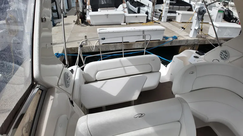 Slide: The Image of 2005 Regal Commodore 2860 boat interior with white seating at a marina. - 20