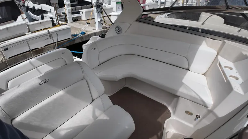 Slide: The Image of 2005 Regal Commodore 2860 boat interior with white seating at a marina. - 21