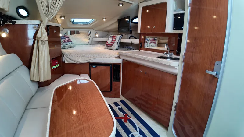 Slide: The Image of 2005 Regal Commodore 2860 cabin interior with wood finish, kitchenette, and seating area. - 24