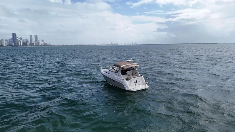 Slide: The Image of 2005 Regal Commodore 2860 boat on open water with city skyline in background. - 3