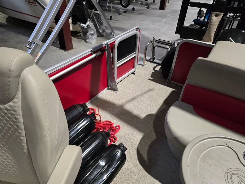 Slide: The Image of Interior of 2022 Premier 210 SunSation RE pontoon boat with beige seating and red accents. - 12