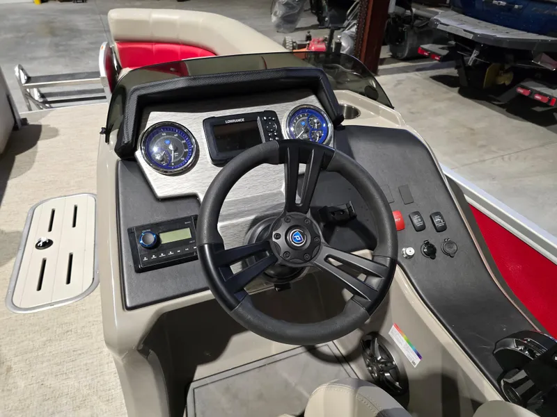 Slide: The Image of 2022 Premier 210 SunSation RE boat dashboard with steering wheel and control panel. - 7