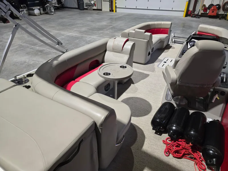 Slide: The Image of 2022 Premier 210 SunSation RE pontoon boat interior with beige seating and red accents. - 9