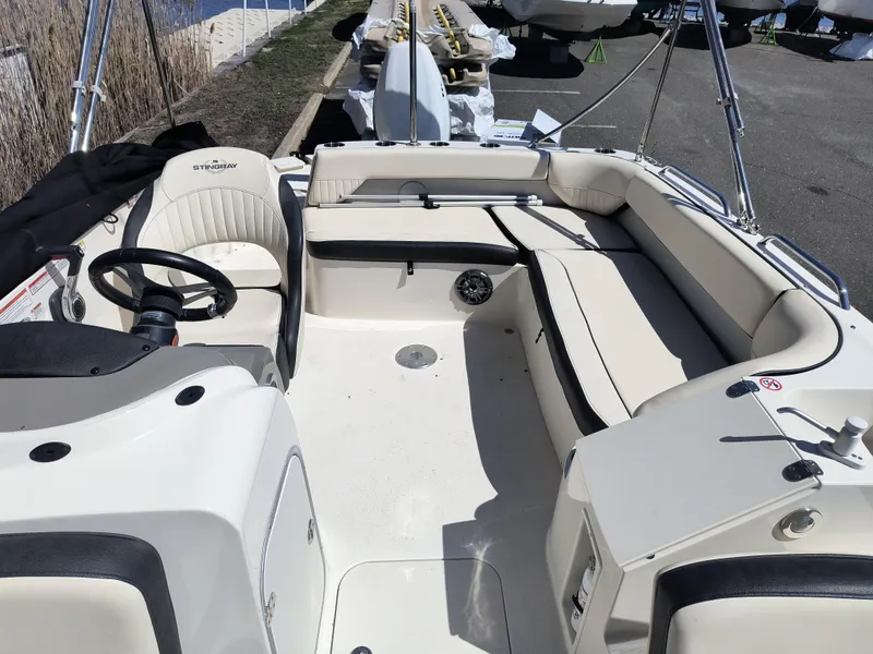 Slide: The Image of 2021 Stingray 192 SC boat interior with beige seating and steering wheel. - 4