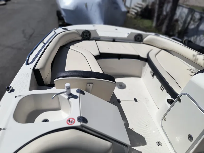 Slide: The Image of 2021 Stingray 192 SC boat interior with beige seating and a small sink. - 7