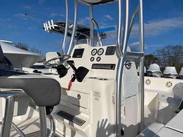 Slide: The Image of 2020 Tidewater 198CC boat interior with steering console and seating under blue sky. - 6