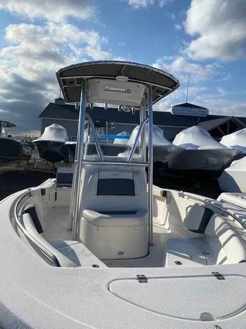 Slide: The Image of 2020 Tidewater 198CC boat with T-top, docked under a partly cloudy sky. - 8