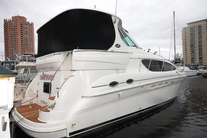 The Image of 2005 Sea Ray 390 Motor Yacht docked at marina, overcast sky. - 0