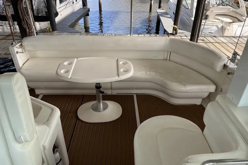 Slide: The Image of 2005 Sea Ray 390 Motor Yacht interior with white seating and table, docked at marina. - 11