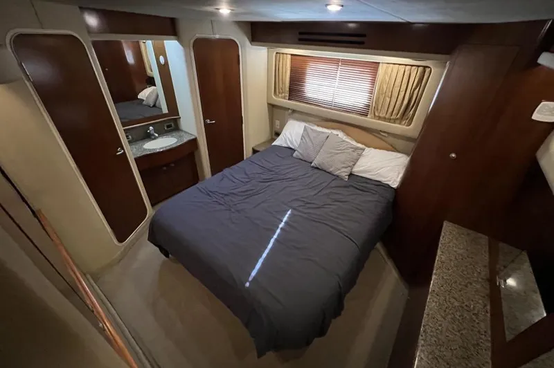 Slide: The Image of Luxurious bedroom interior of 2005 Sea Ray 390 Motor Yacht with cozy bed and wooden accents. - 26