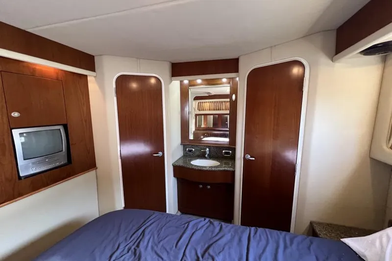Slide: The Image of 2005 Sea Ray 390 Motor Yacht interior with wood paneling, TV, and vanity area. - 27