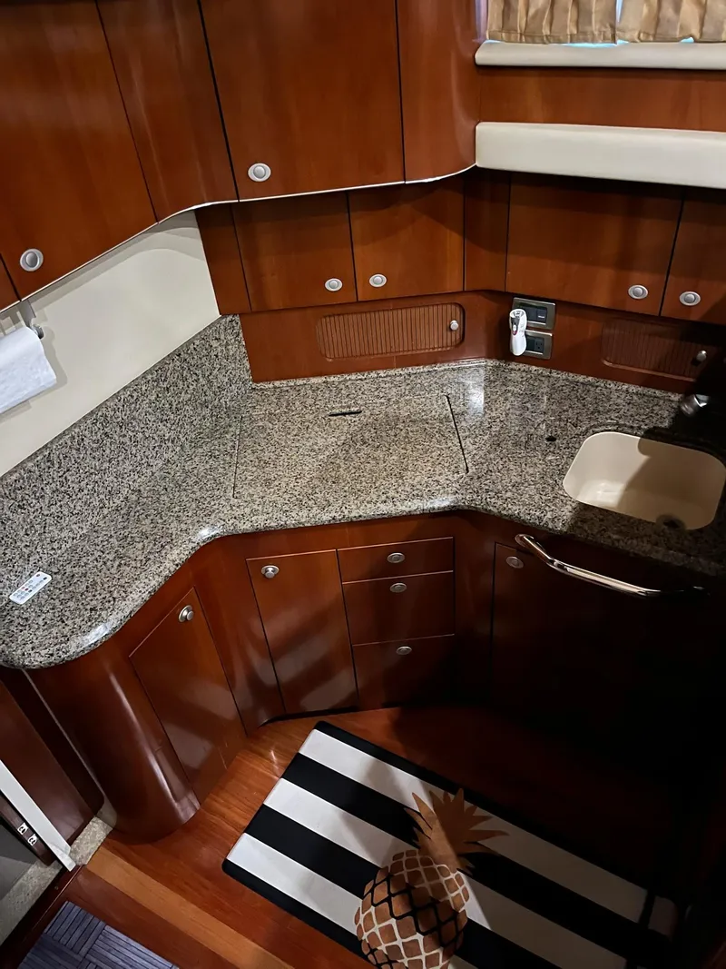 Slide: The Image of 2005 Sea Ray 390 Motor Yacht kitchen with granite countertops and wooden cabinetry. - 32
