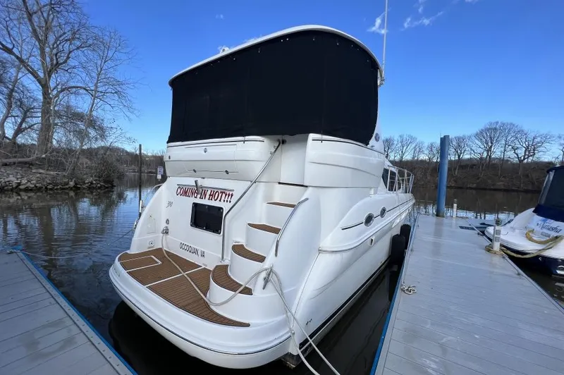 Slide: The Image of 2005 Sea Ray 390 Motor Yacht docked, rear view with black canopy and wooden deck. - 4