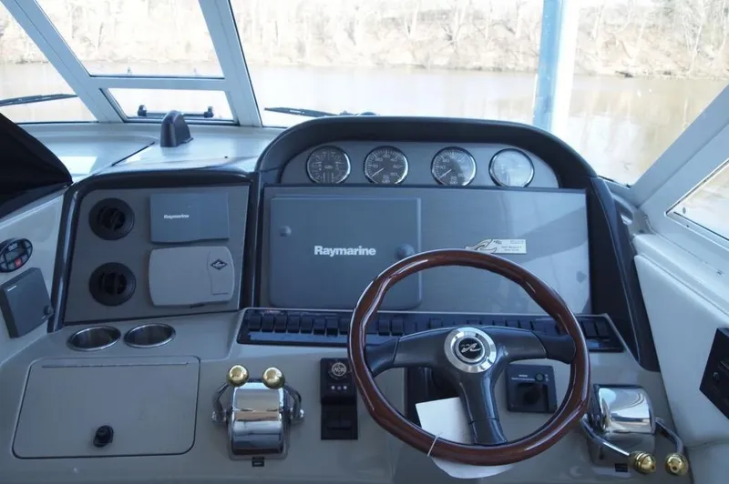 Slide: The Image of 2005 Sea Ray 390 Motor Yacht helm with Raymarine navigation system and wooden steering wheel. - 5