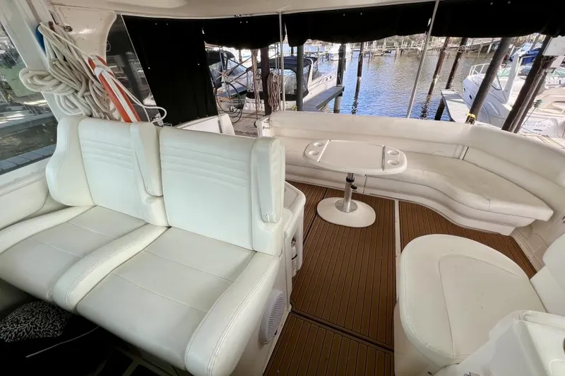 Slide: The Image of 2005 Sea Ray 390 Motor Yacht interior with white seating and table, docked at marina. - 7
