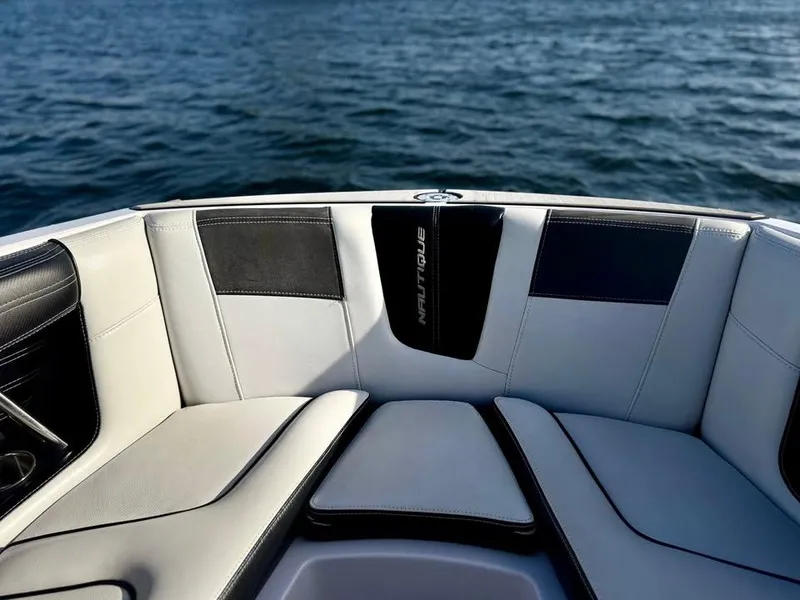Slide: The Image of 2015 Nautique Super Air Nautique G21 boat interior with cushioned seating, on water. - 15
