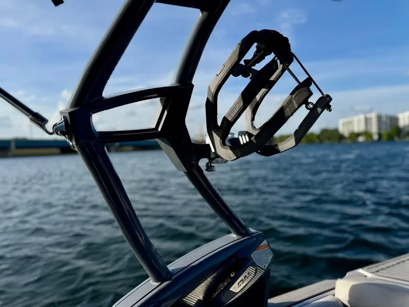 Slide: The Image of 2015 Nautique Super Air Nautique G21 wakeboard rack on a sunny day by the water. - 16