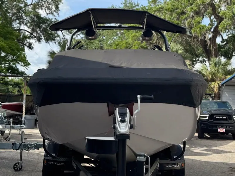 Slide: The Image of 2015 Nautique Super Air Nautique G21 boat on trailer, covered and parked outdoors. - 2