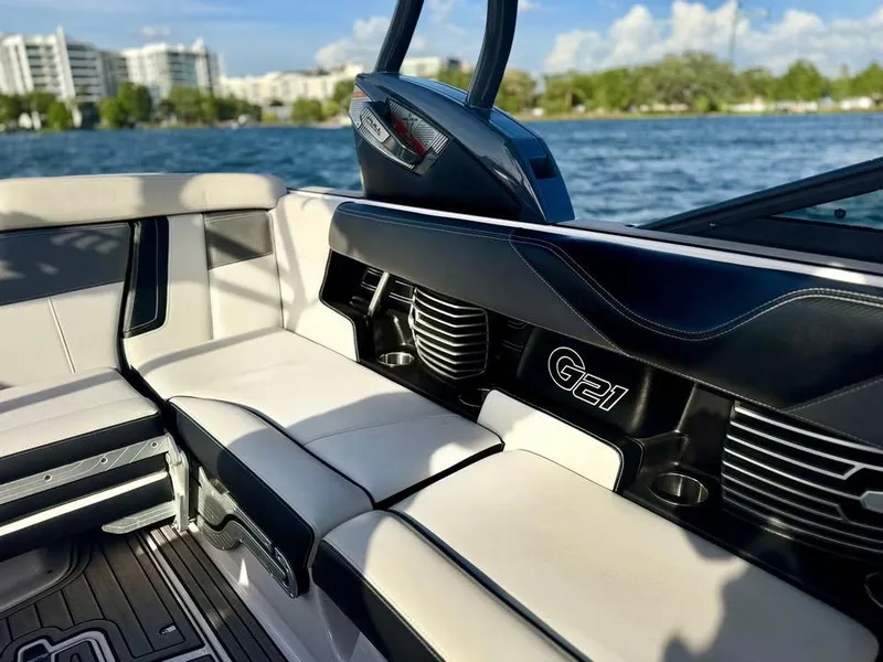 Slide: The Image of 2015 Nautique Super Air Nautique G21 interior with luxurious seating, on a sunny waterfront. - 7