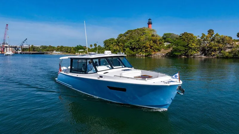 Slide: The Image of 2024 MJM 4 boat cruising near a lighthouse on a sunny day. - 19