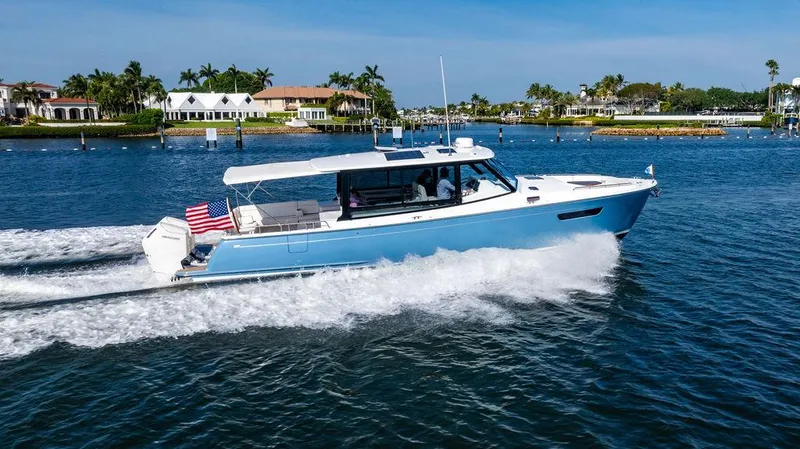 Slide: The Image of 2024 MJM 4 boat cruising on a sunny waterfront with luxury homes in the background. - 3