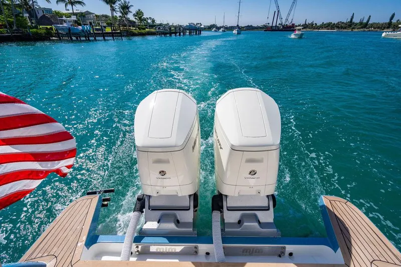 Slide: The Image of 2024 MJM 4 boat with dual engines cruising on clear blue water. - 36