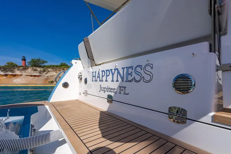 Slide: The Image of 2024 MJM 4 boat named "Happyness" docked in Jupiter, FL, with lighthouse in background. - 42