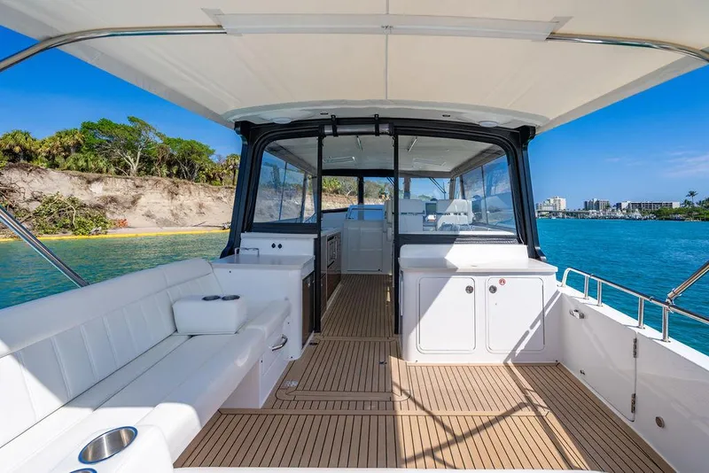 Slide: The Image of 2024 MJM 4 boat interior with seating, teak flooring, and ocean view. - 43