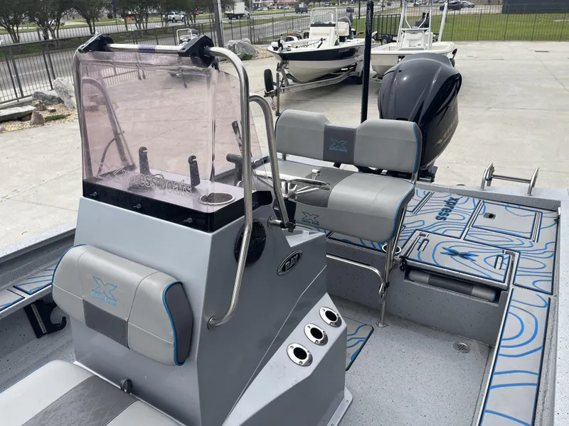 Slide: The Image of 2020 Xpress X23B boat interior with seating, console, and motor, displayed outdoors. - 13