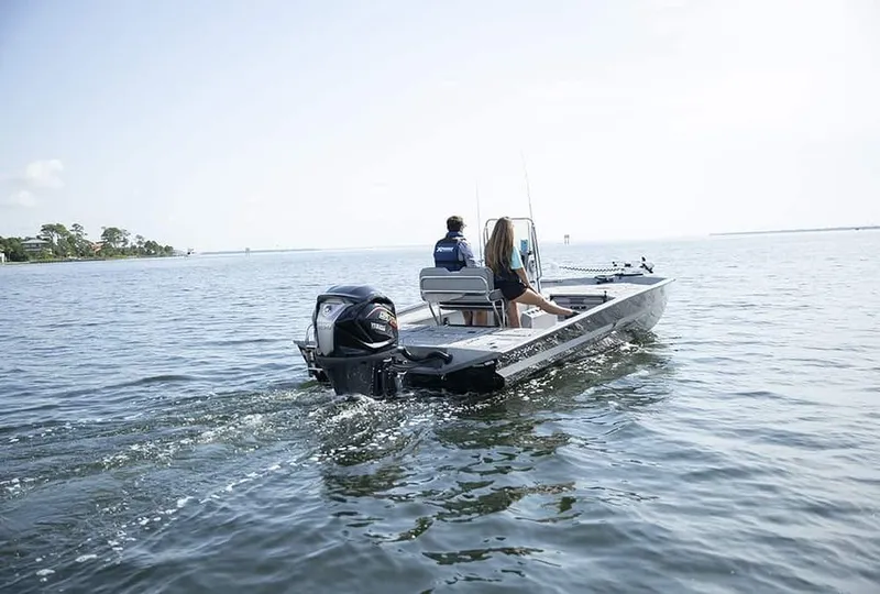 Slide: The Image of 2020 Xpress X23B boat cruising on open water with two passengers. - 17