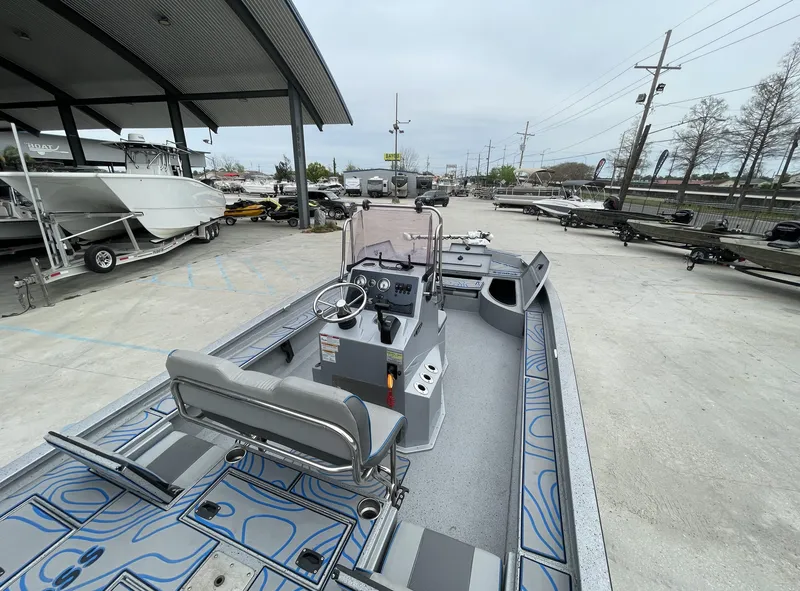 Slide: The Image of 2020 Xpress X23B boat with modern interior, parked at a dealership. - 7