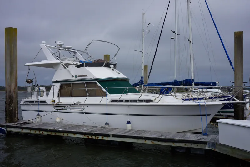Slide: The Image of 1986 President 37 Sundeck yacht docked at marina under cloudy sky. - 1
