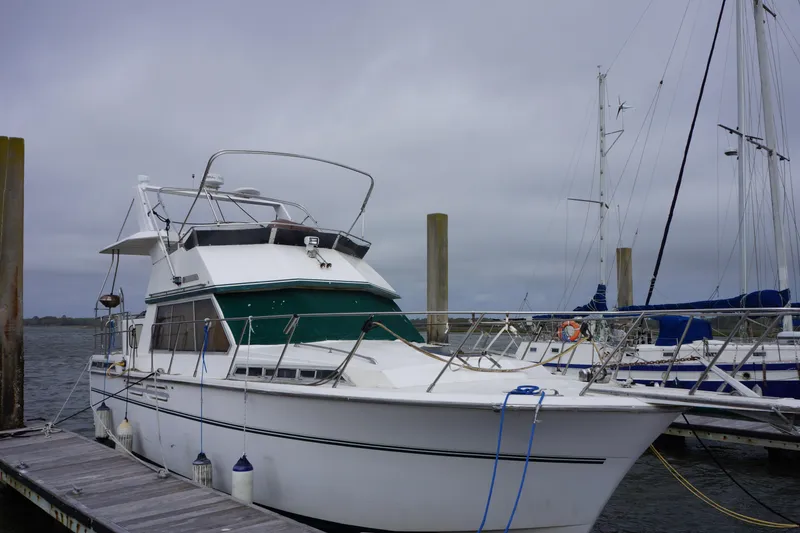Slide: The Image of 1986 President 37 Sundeck yacht docked at marina under cloudy skies. - 2
