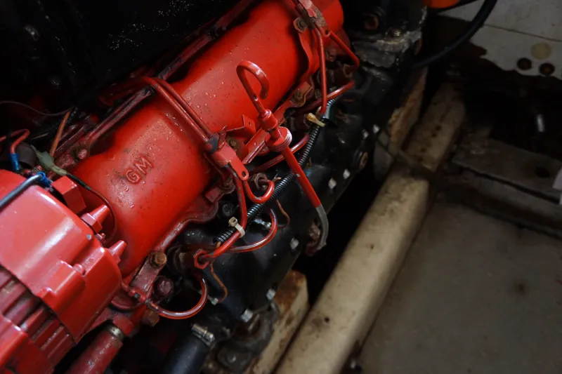 Slide: The Image of Engine of a 1986 President 37 Sundeck boat, featuring red components and visible wiring. - 9