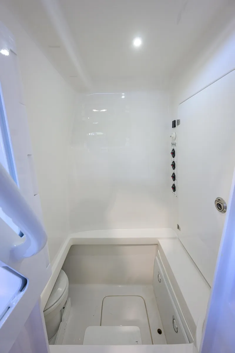 Slide: The Image of 2025 Contender 32 ST boat interior, featuring a compact, modern bathroom with white fixtures. - 18