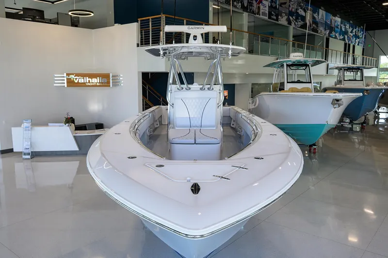 Slide: The Image of 2025 Contender 32 ST boat displayed in a showroom, featuring sleek design and modern amenities. - 2