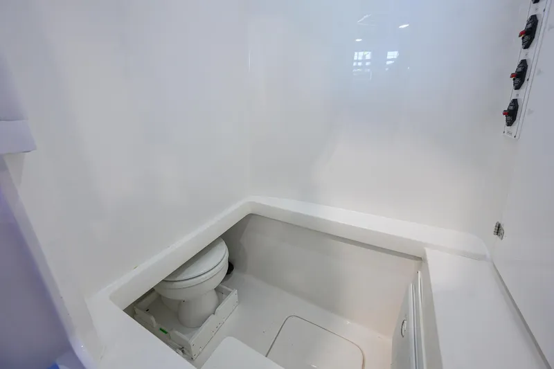 Slide: The Image of 2025 Contender 32 ST boat interior with compact marine toilet and white finish. - 22